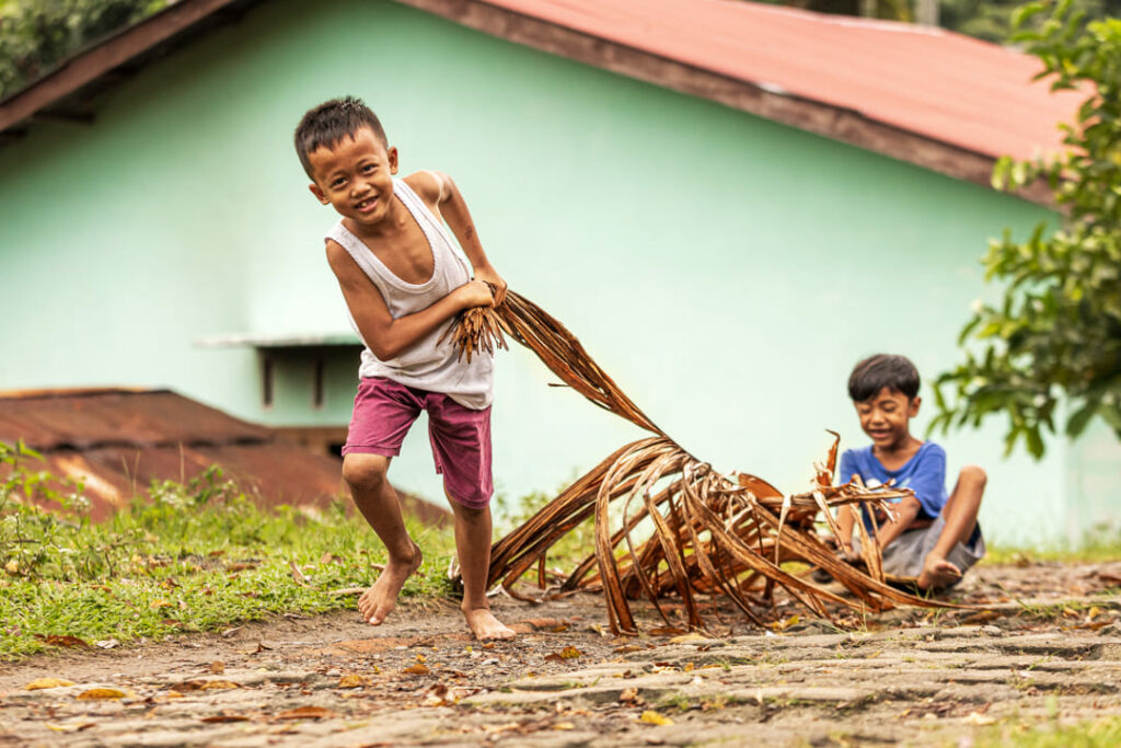 bambini di sumatra che giocano con foglie di banane