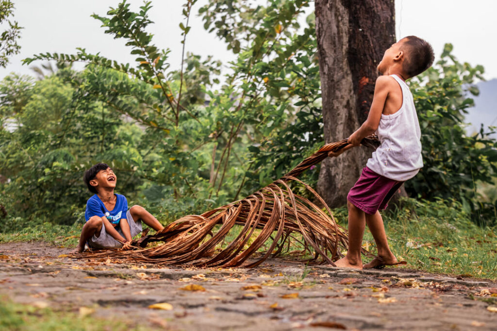 bambini di sumatra che giocano con foglie di banane